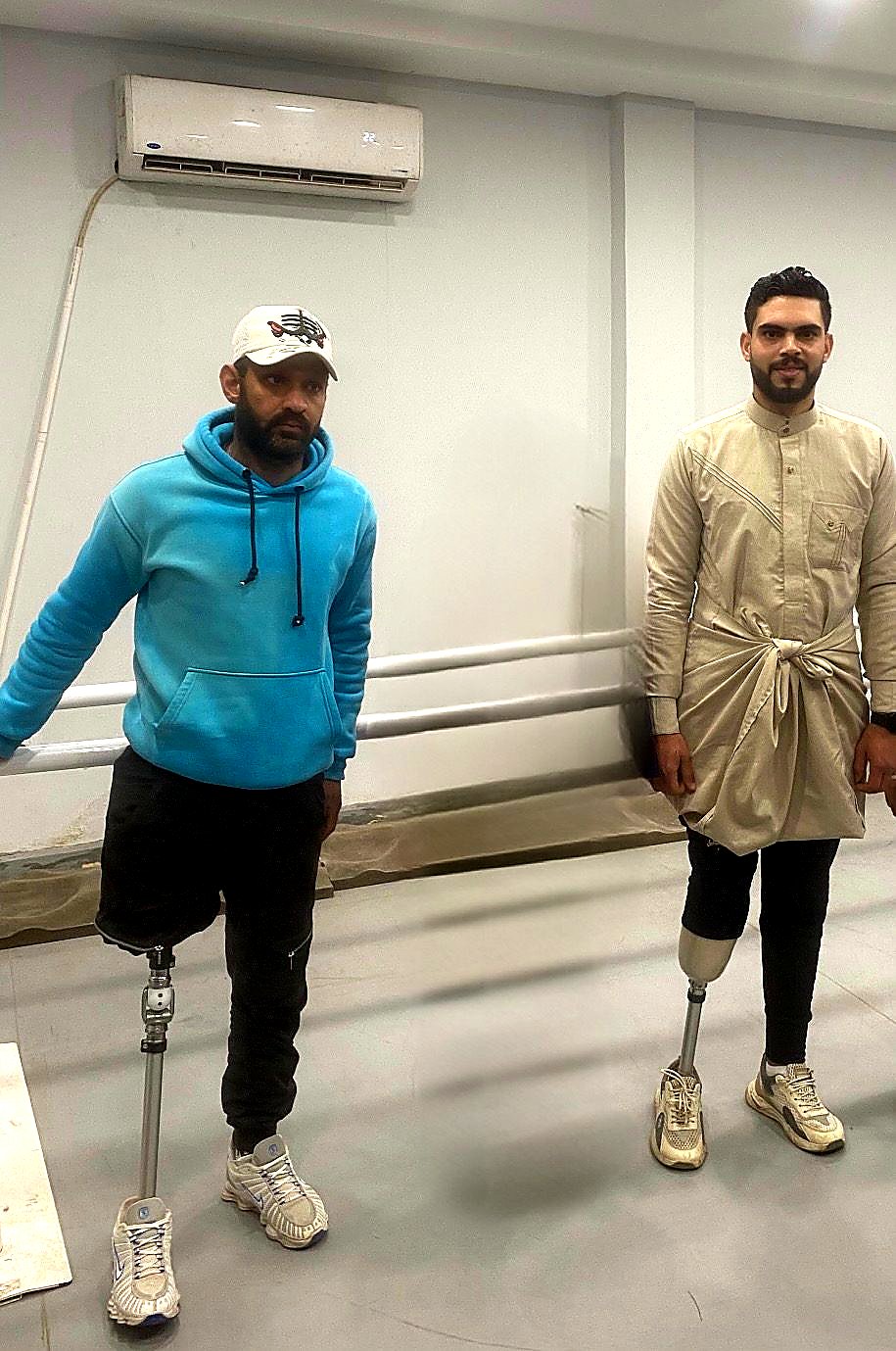 Two beneficiaries standing with new prosthetic limbs