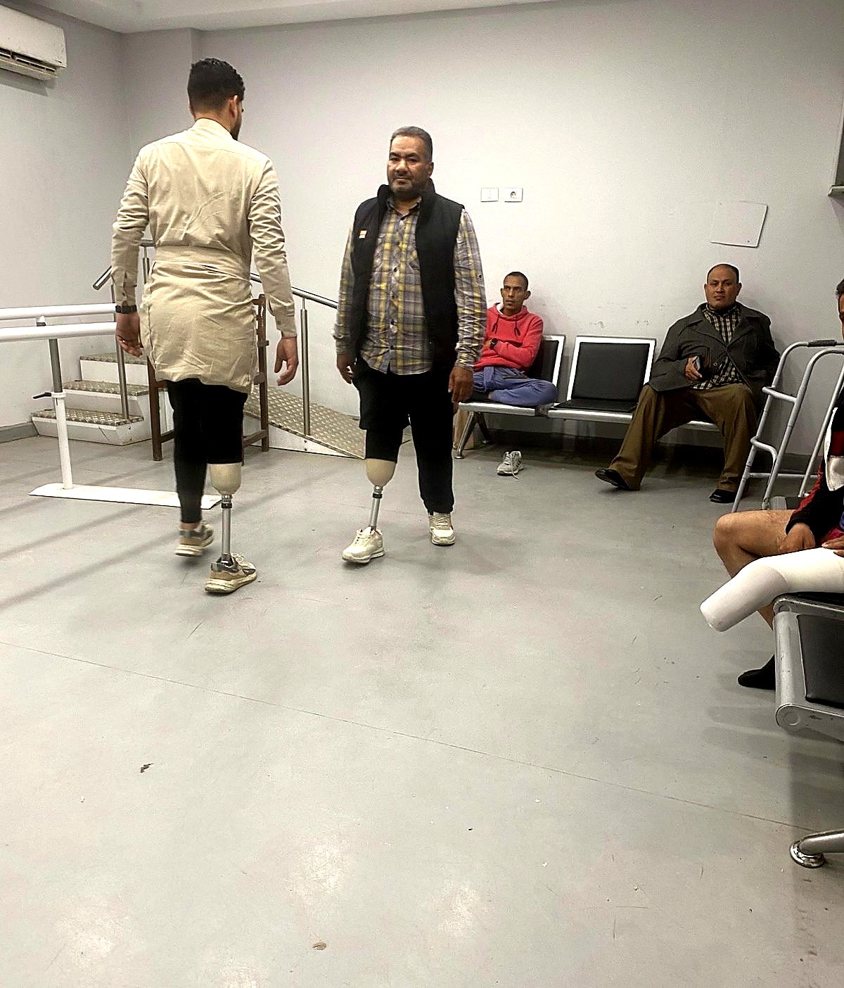 Beneficiaries learning to walk between parallel bars